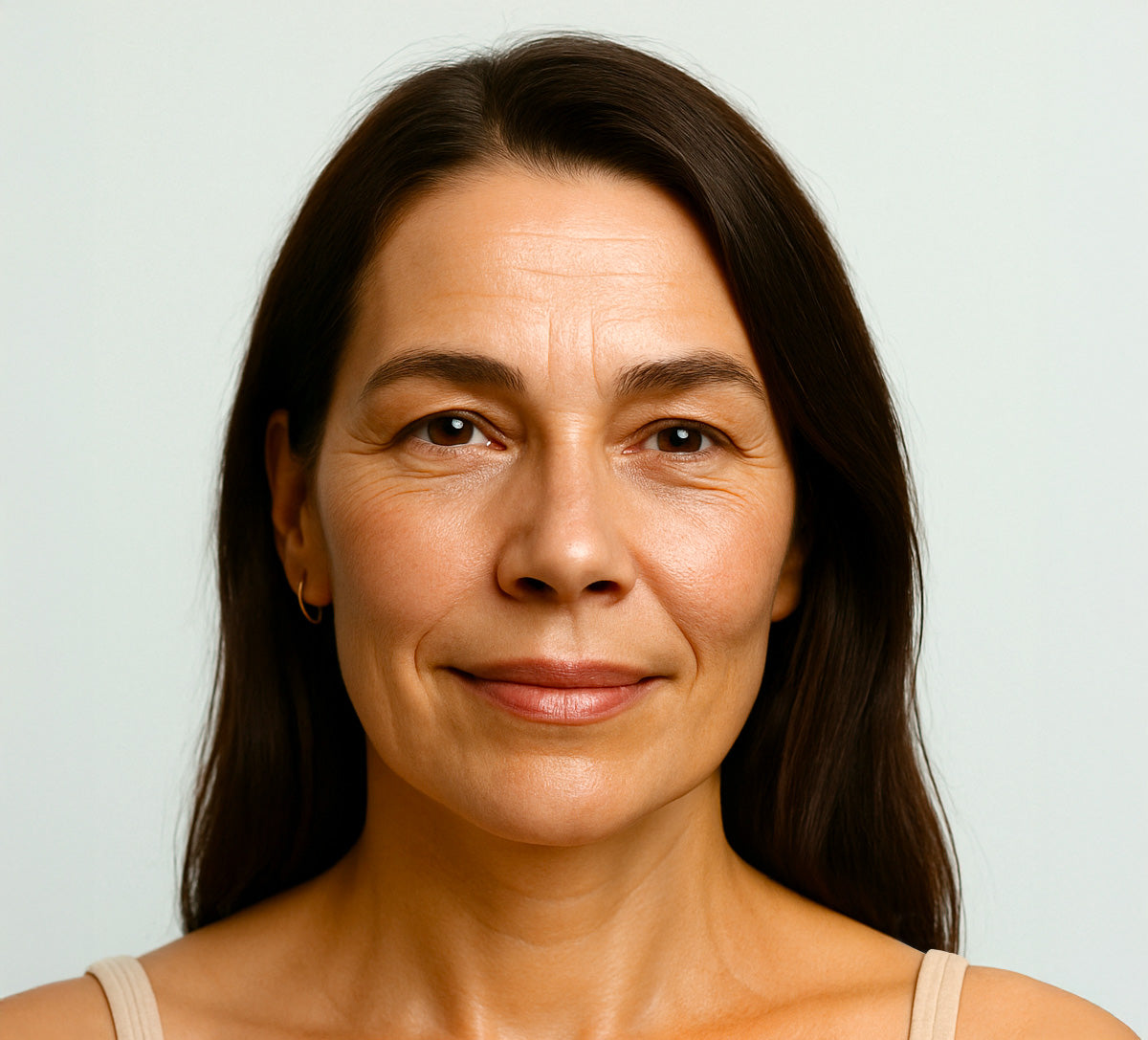 Middle-aged woman with smooth, natural skin and visible fine lines, smiling gently. Showing results before using anti-wrinkle patches by Bare Intent