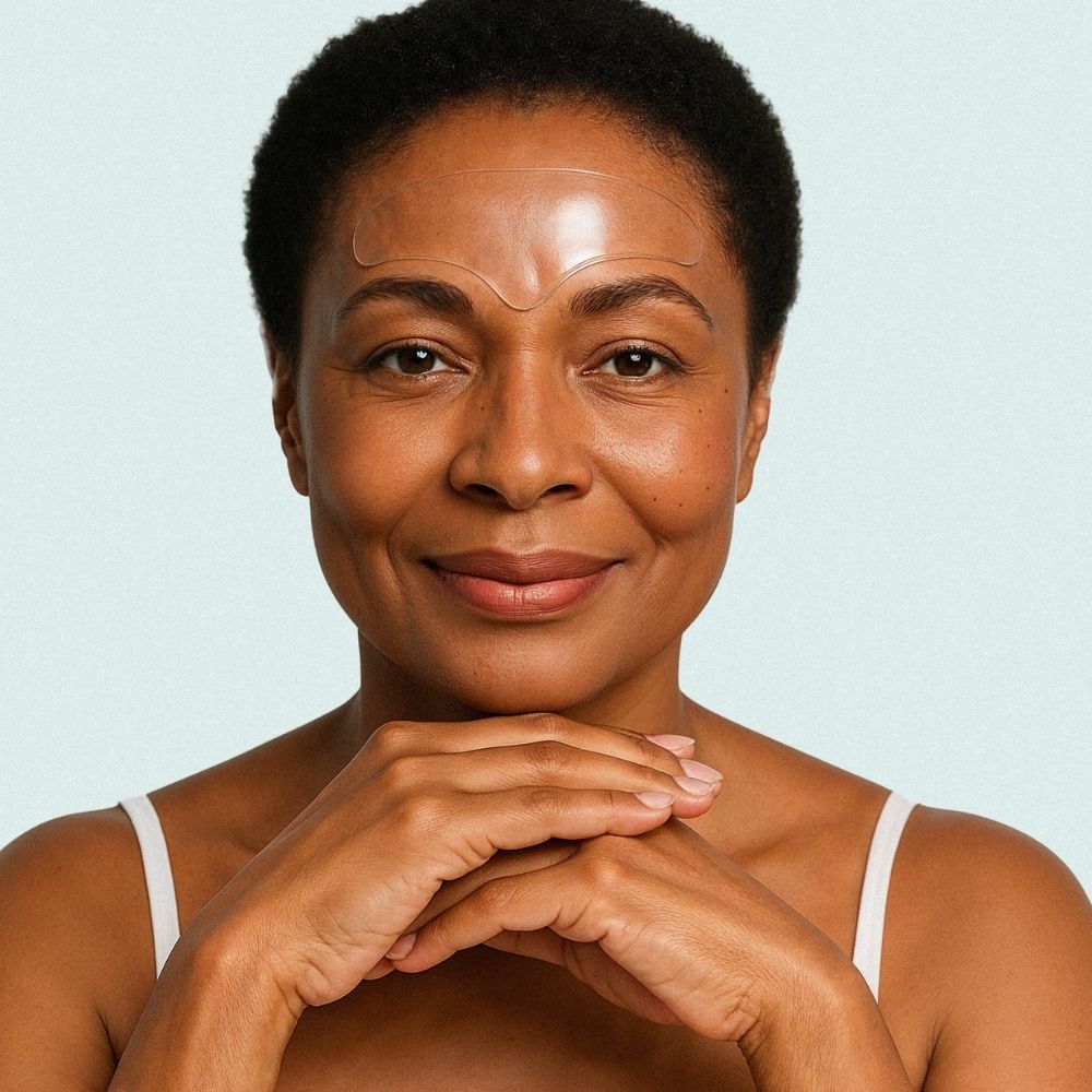 Smiling woman wearing reusable forehead patch for wrinkle-smoothing treatment – Bare Intent minimalist skincare